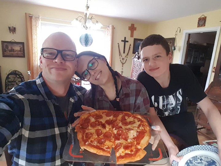 man, woman, and son smiling at home