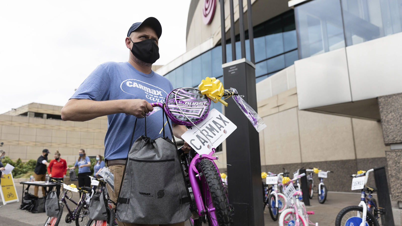 Photo of a person carrying a child's bike.