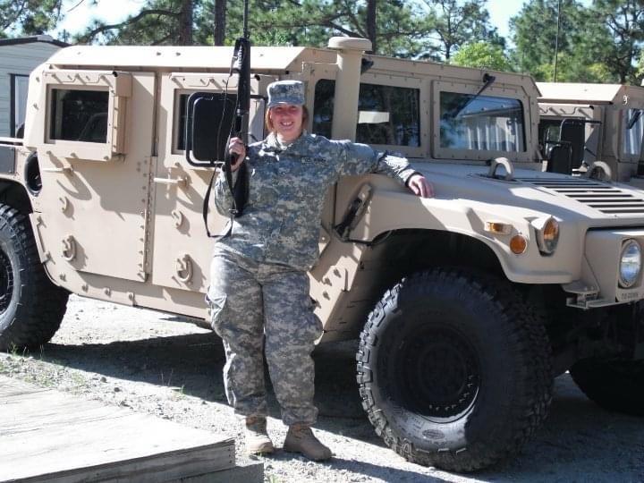 military veteran standing in front of tank