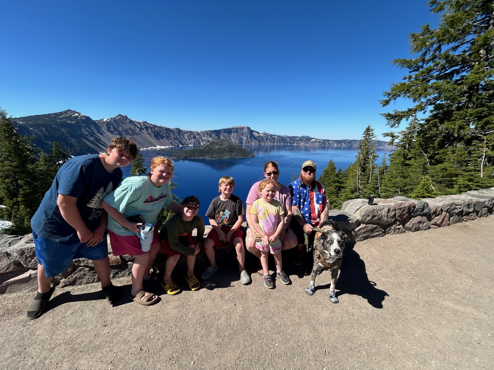family with dog posing for photo in mountains