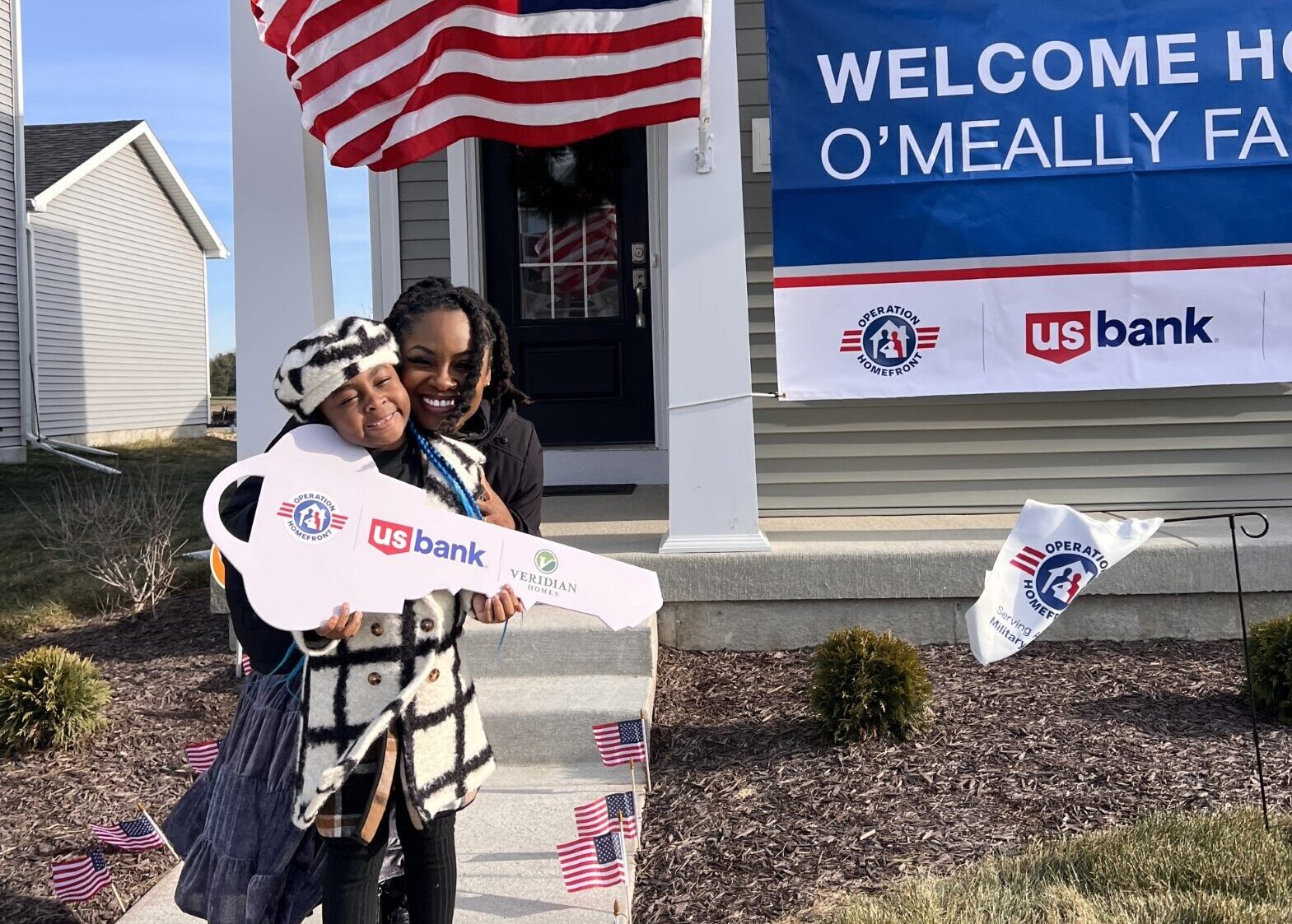 mom and daughter receiving key to new home