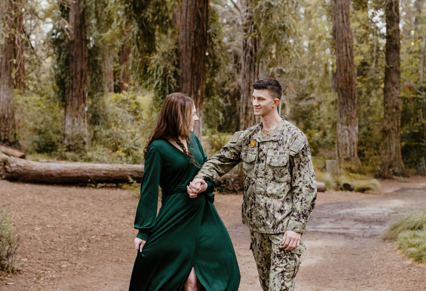 man in uniform holding hands with woman in green dress