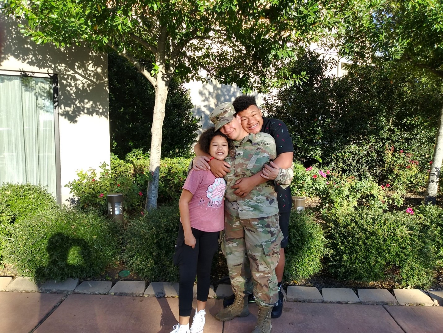 woman in her uniform being hugged by two children