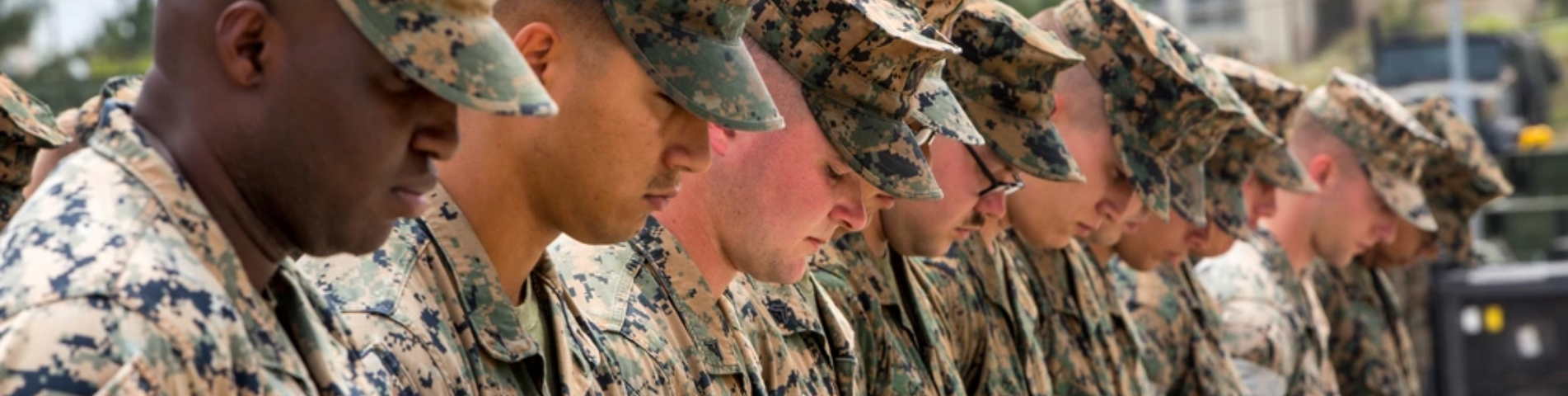 men in uniform with bowed heads